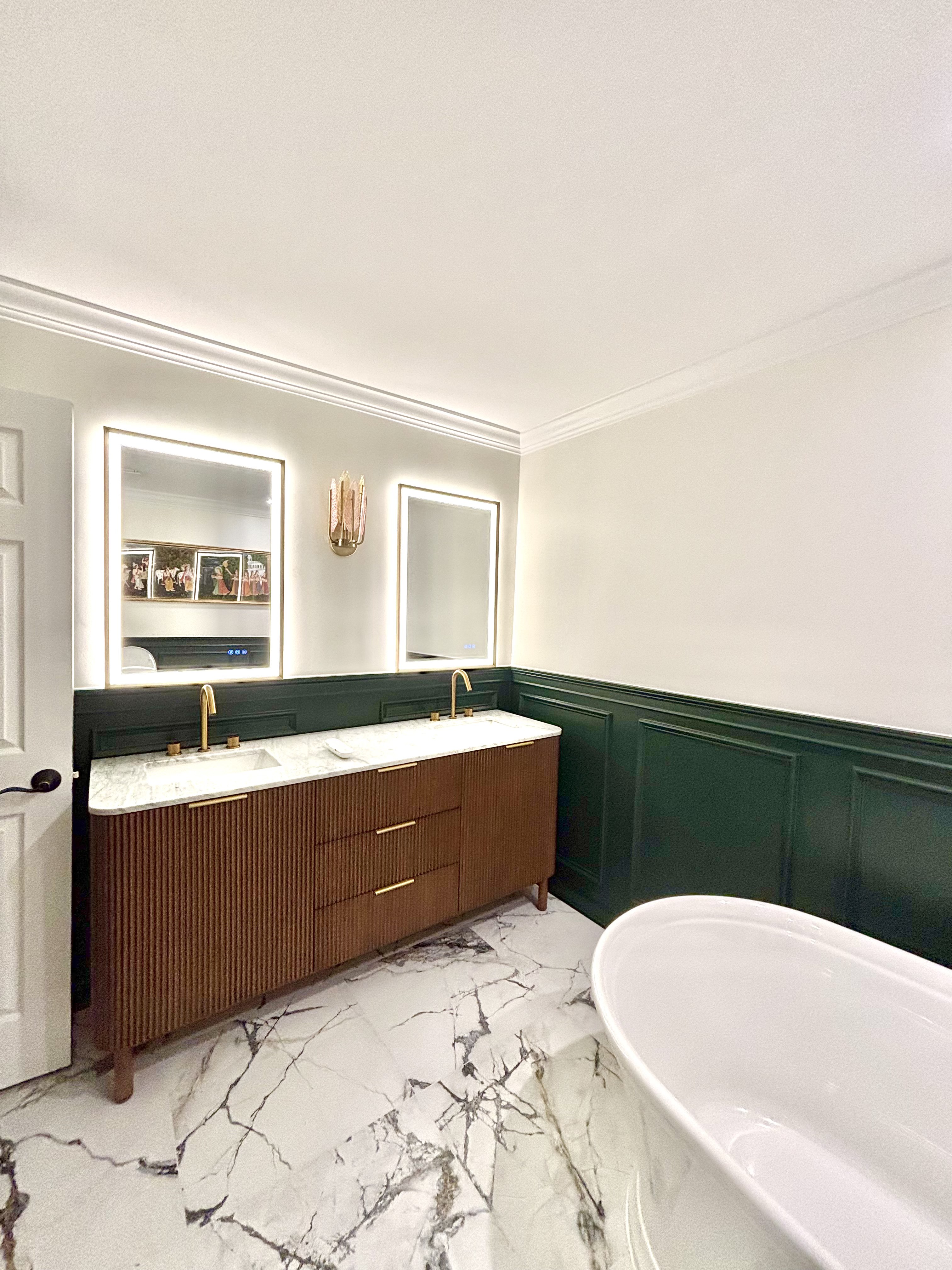 Master bathroom remodel by Beaver Home Design Build with double vanity, backlit mirrors and green wainscoting