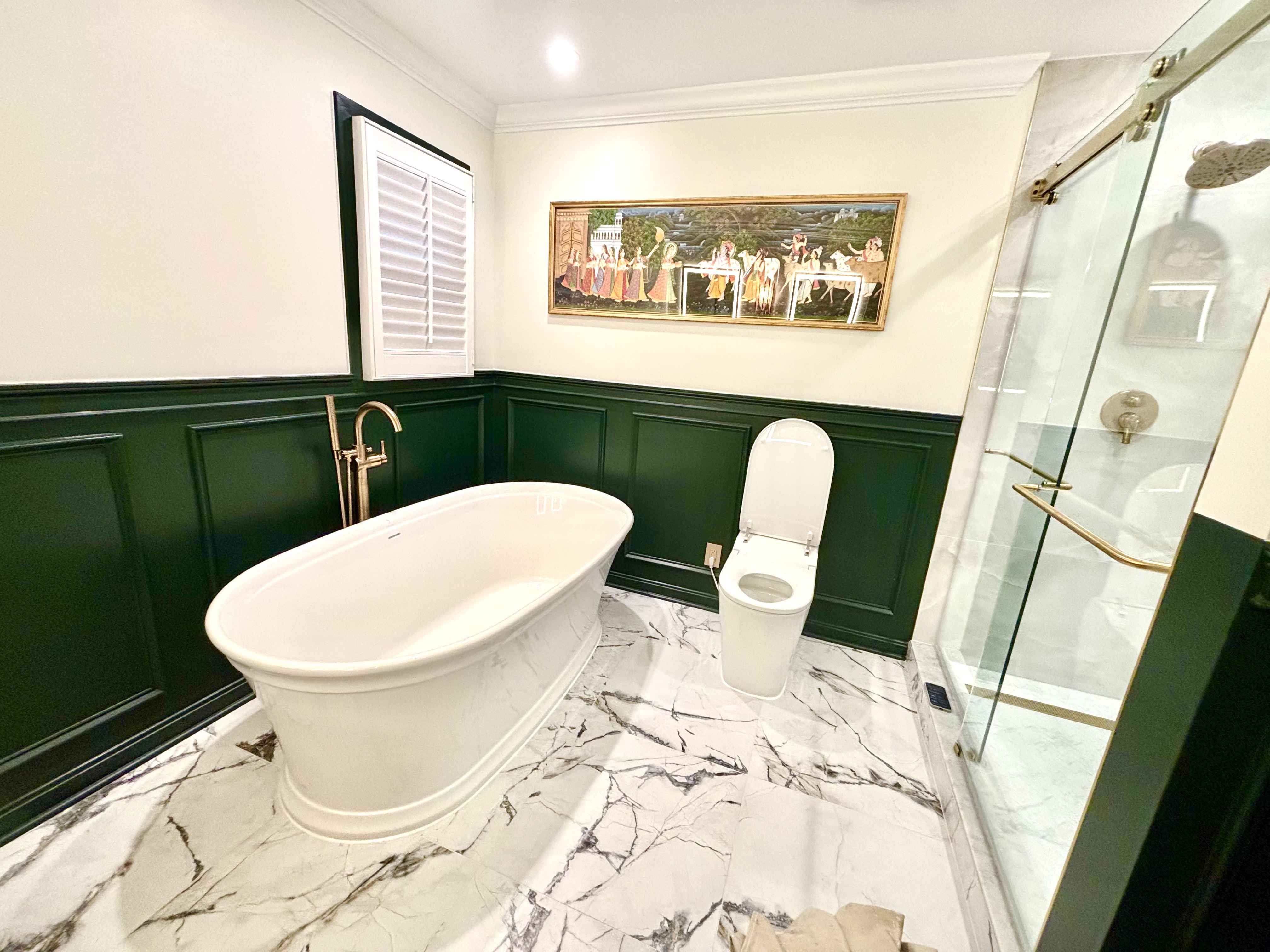 Freestanding tub, smart toilet and glass walk-in shower with gold hardware